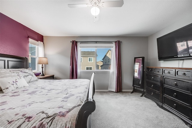 carpeted bedroom with multiple windows and ceiling fan