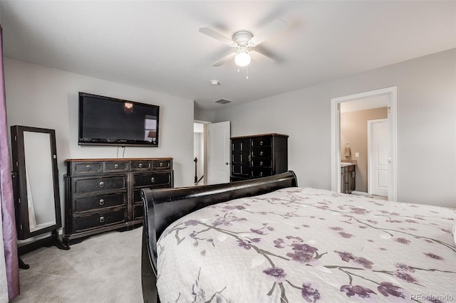 bedroom featuring ensuite bath, light colored carpet, and ceiling fan