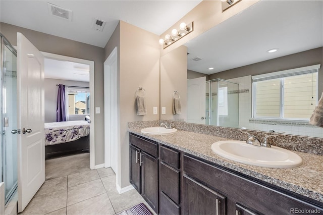 bathroom featuring tile patterned flooring, a shower with door, and vanity