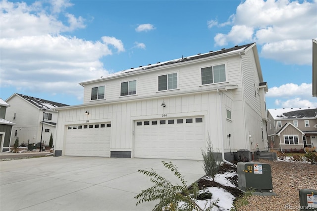 view of front of home with a garage and cooling unit