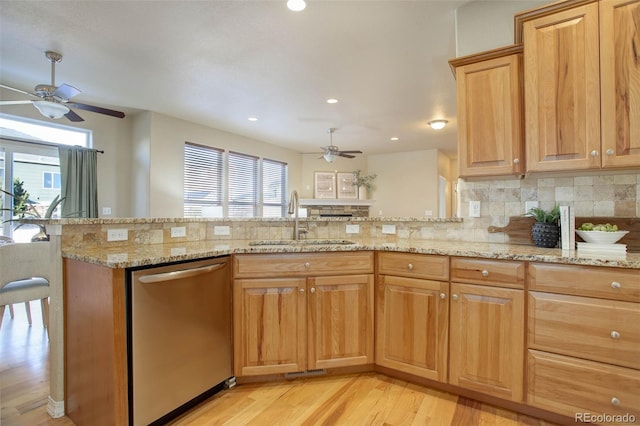 kitchen with dishwasher, sink, tasteful backsplash, light stone counters, and kitchen peninsula