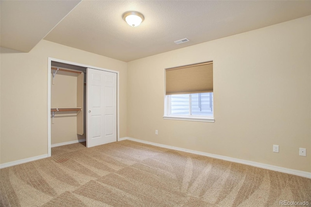 unfurnished bedroom featuring carpet floors and a closet