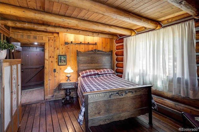 bedroom with beam ceiling, dark wood-type flooring, wooden ceiling, and log walls