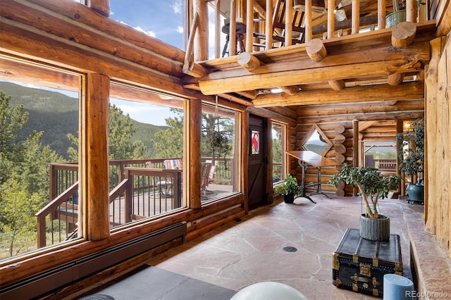 sunroom with baseboard heating and a mountain view