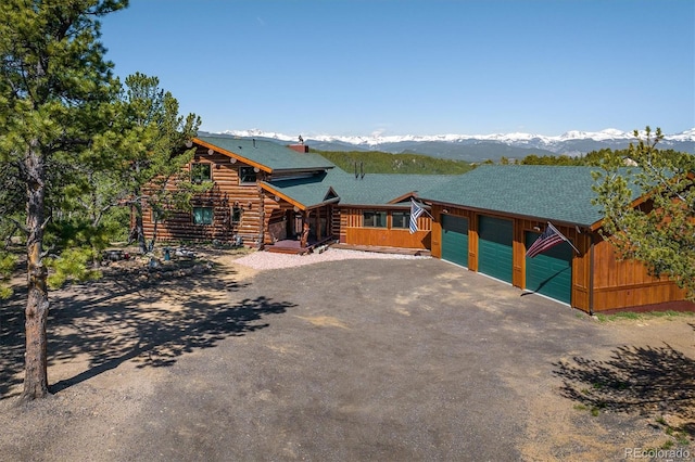 log-style house featuring a garage and a mountain view