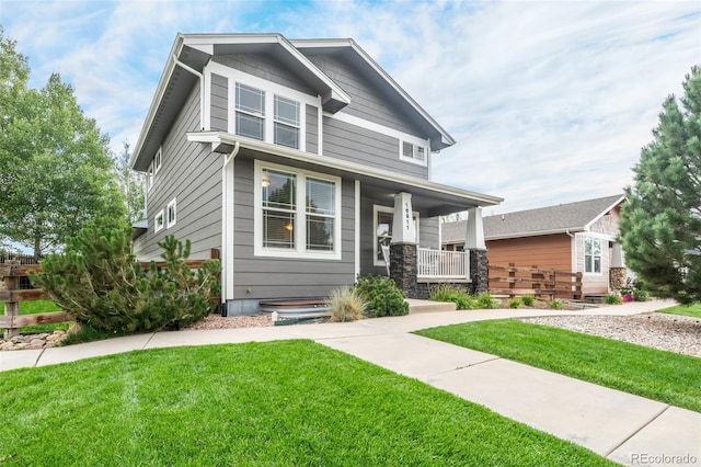 craftsman inspired home featuring a porch and a front yard