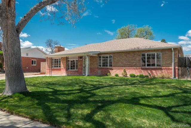 single story home featuring brick siding, a front lawn, and a chimney