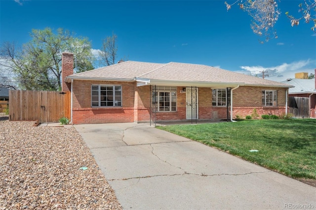 ranch-style house featuring covered porch, a front yard, a chimney, brick siding, and driveway