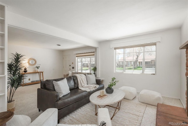 carpeted living area with a brick fireplace