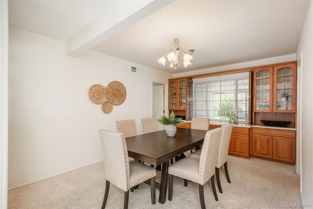dining area featuring an inviting chandelier, light carpet, baseboards, beamed ceiling, and visible vents