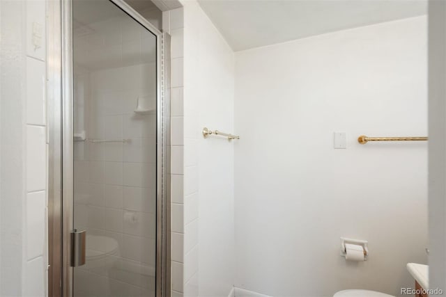 bathroom featuring toilet and a stall shower