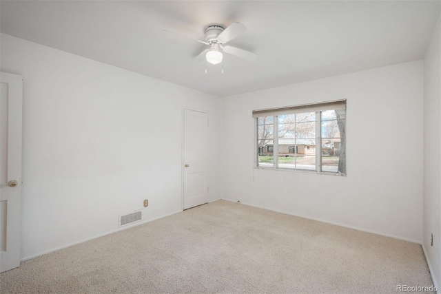 unfurnished room with visible vents, a ceiling fan, baseboards, and carpet flooring