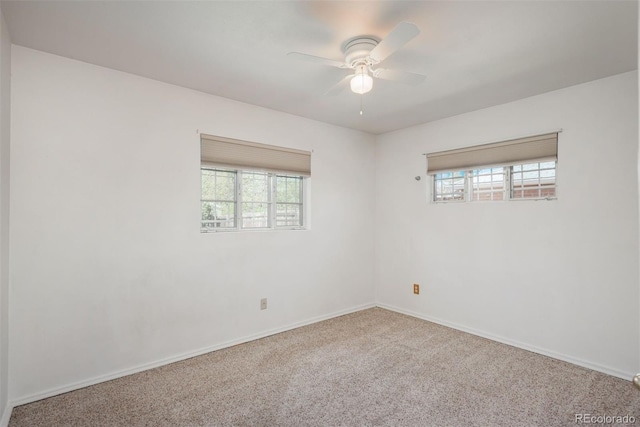 carpeted spare room with baseboards, ceiling fan, and a healthy amount of sunlight