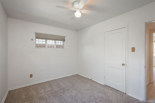 spare room featuring carpet floors, ceiling fan, and baseboards