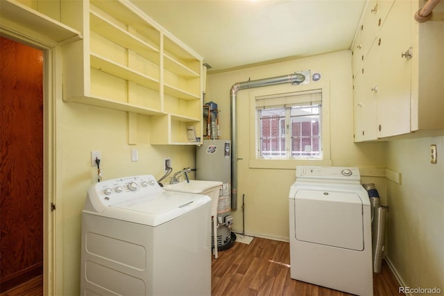 clothes washing area featuring cabinet space, dark wood finished floors, water heater, baseboards, and washer and clothes dryer