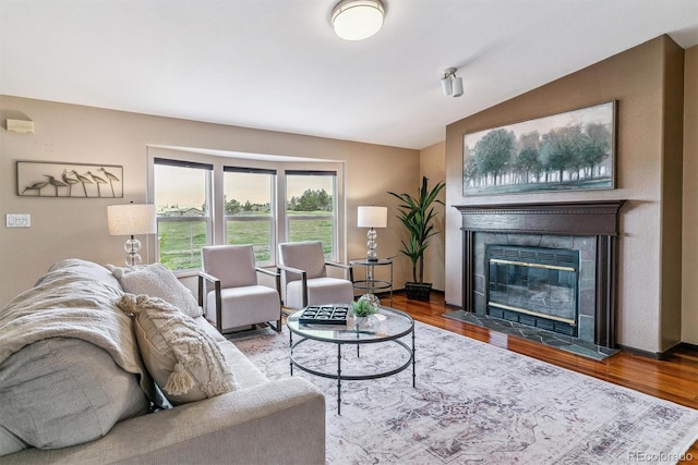 40192 Margaret Dr, Elizabeth, CO 80107 - living area featuring lofted ceiling, a tiled fireplace, and wood finished floors