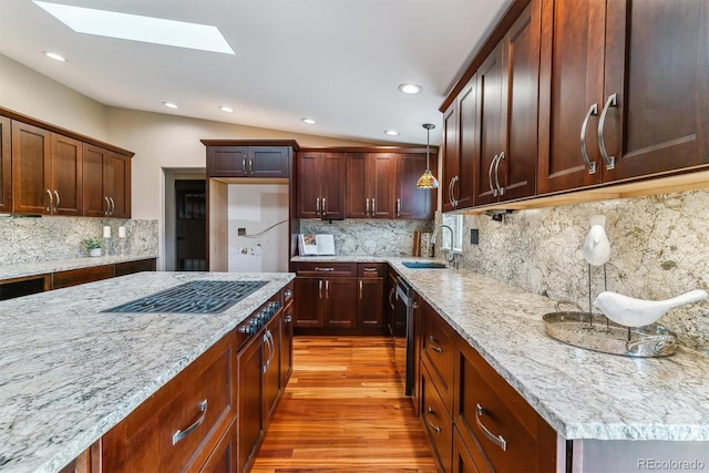 40192 Margaret Dr, Elizabeth, CO 80107 - kitchen featuring a sink, wood finished floors, a skylight, light stone countertops, and backsplash