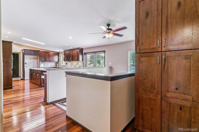 40192 Margaret Dr, Elizabeth, CO 80107 - kitchen featuring decorative backsplash, a ceiling fan, light wood-type flooring, a peninsula, and recessed lighting