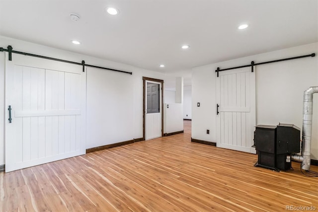 40192 Margaret Dr, Elizabeth, CO 80107 - unfurnished bedroom with a barn door, light wood-type flooring, baseboards, and recessed lighting