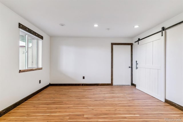 40192 Margaret Dr, Elizabeth, CO 80107 - spare room with a barn door, light wood-style flooring, baseboards, and recessed lighting