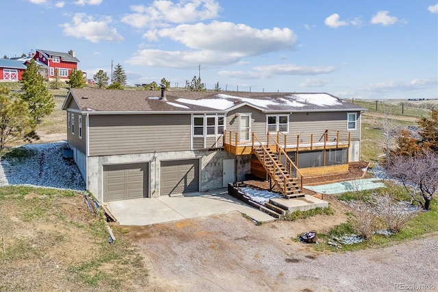 40192 Margaret Dr, Elizabeth, CO 80107 - view of front of home featuring dirt driveway, an attached garage, stairway, and a wooden deck