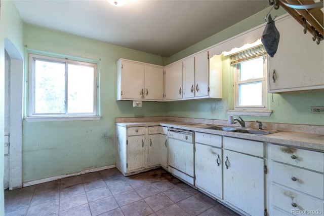 1335 Locust St, Denver, CO 80220 - kitchen with dishwasher, white cabinets, light countertops, and light tile patterned floors