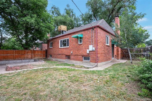1335 Locust St, Denver, CO 80220 - view of side of home featuring a chimney, a fenced backyard, and brick siding