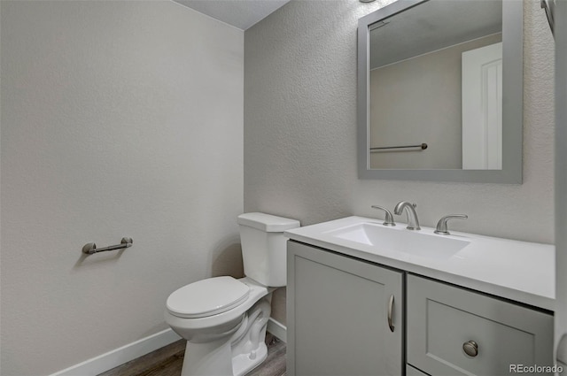 bathroom featuring vanity, hardwood / wood-style flooring, and toilet