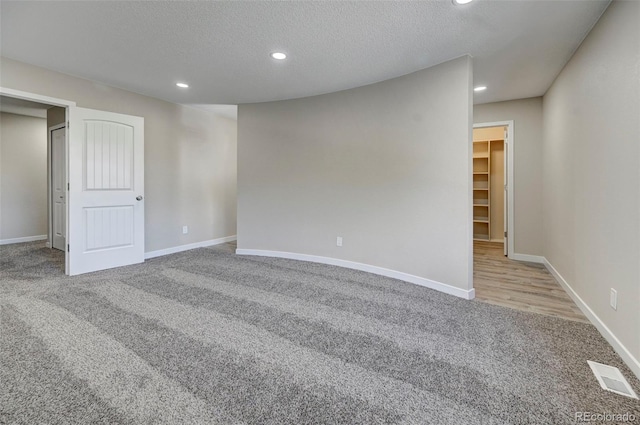 empty room featuring light carpet and a textured ceiling