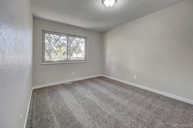 carpeted empty room with a textured ceiling