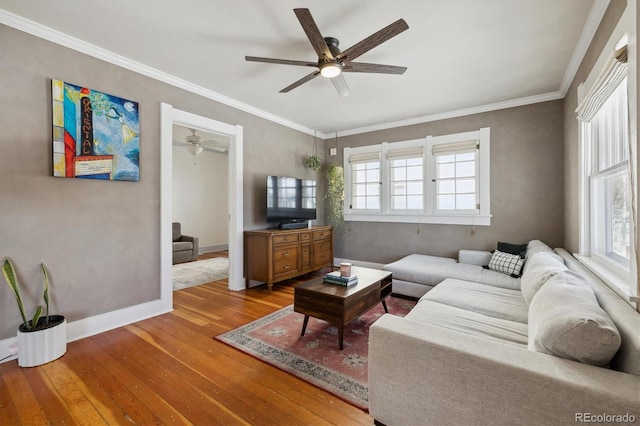 living room with hardwood / wood-style floors, ornamental molding, and ceiling fan