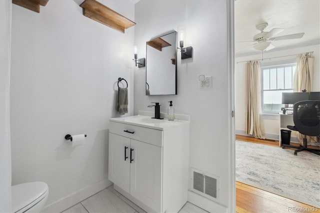 bathroom featuring vanity, hardwood / wood-style floors, ceiling fan, and toilet