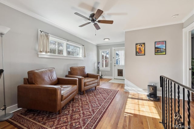 living area featuring hardwood / wood-style flooring, ceiling fan, and ornamental molding