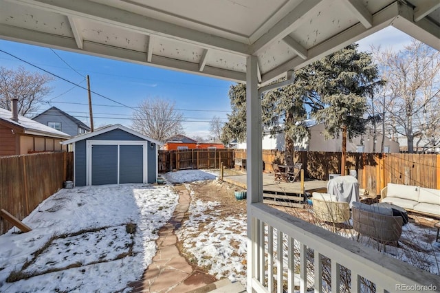 snowy yard featuring a shed and an outdoor hangout area