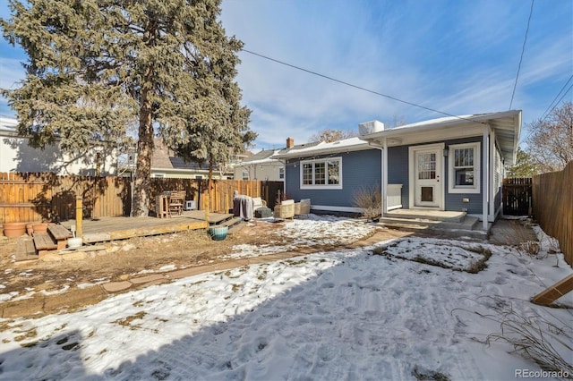 snow covered house with a wooden deck