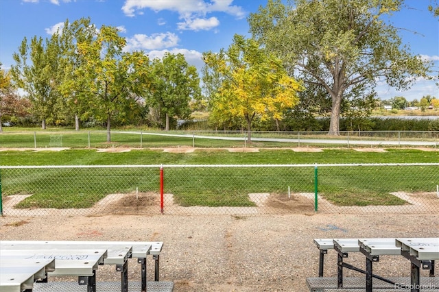 view of property's community with a lawn and fence