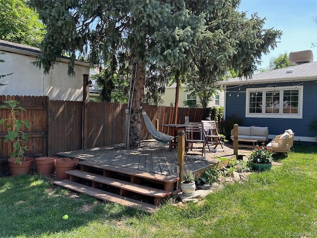 wooden deck featuring outdoor lounge area, fence, and a lawn