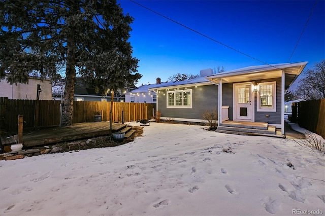 back of property featuring a porch and fence