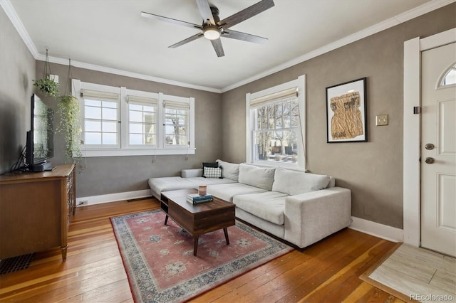 living area featuring ornamental molding, ceiling fan, baseboards, and hardwood / wood-style floors