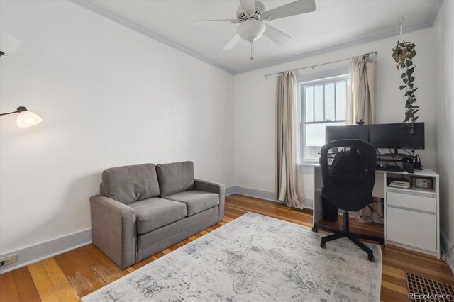 office area with a ceiling fan, wood finished floors, baseboards, and ornamental molding