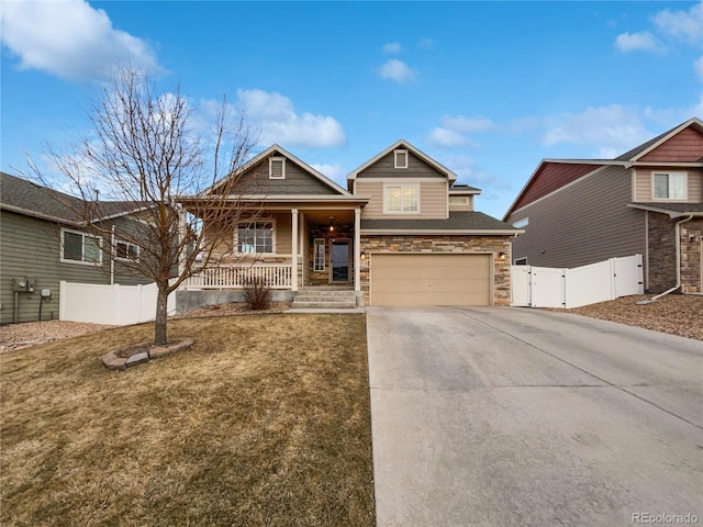 view of front of house with a porch, concrete driveway, an attached garage, a gate, and fence