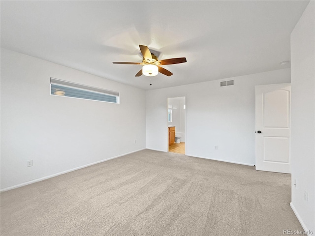 unfurnished bedroom with ensuite bathroom, ceiling fan, visible vents, baseboards, and carpet