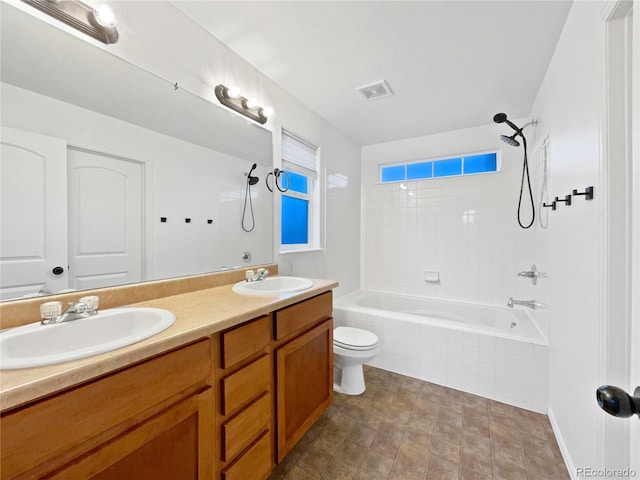 full bathroom with tiled shower / bath, double vanity, a sink, and visible vents