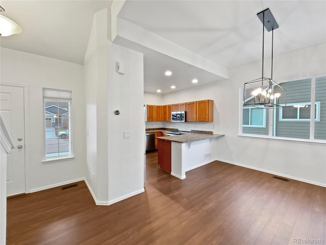 kitchen with a chandelier, stainless steel appliances, dark wood-style flooring, visible vents, and brown cabinets