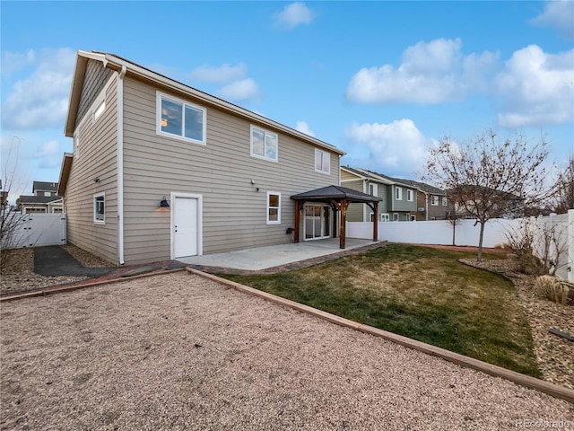 rear view of property with a patio area, a lawn, a fenced backyard, and a gazebo