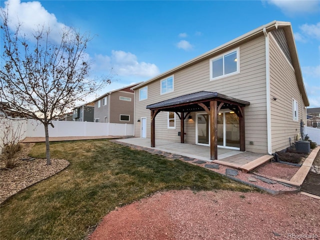 rear view of house with a fenced backyard, a gazebo, cooling unit, a yard, and a patio area