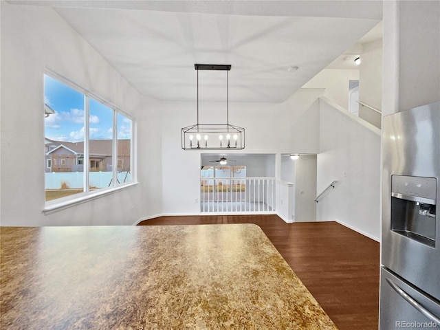 unfurnished dining area featuring dark wood-style flooring and a ceiling fan