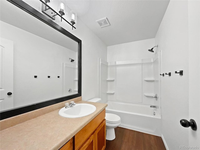 bathroom featuring visible vents, bathing tub / shower combination, toilet, wood finished floors, and vanity