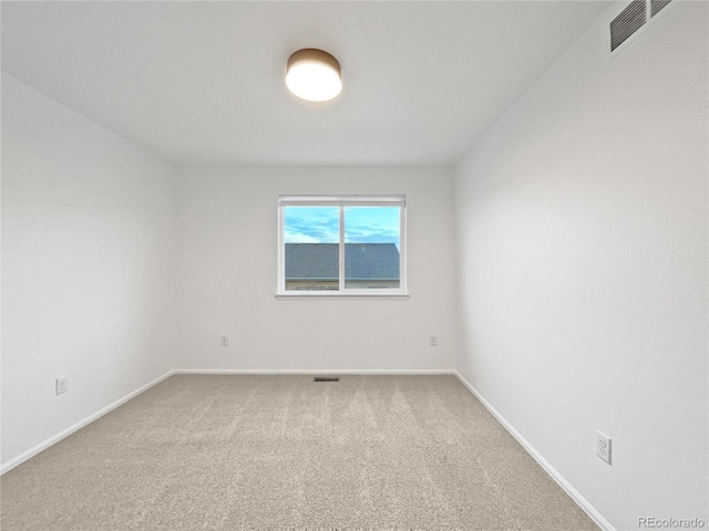 carpeted empty room featuring visible vents and baseboards