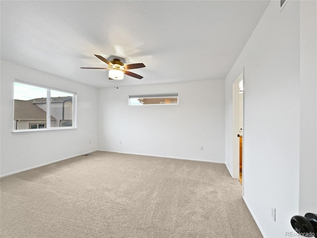 empty room with light carpet, a ceiling fan, and a healthy amount of sunlight